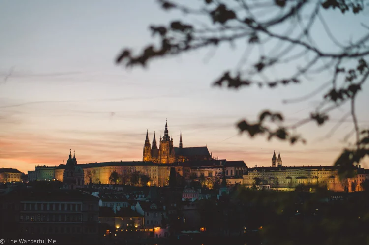The beautiful city of Prague lit up at sunset with Prague Castle in the background. 