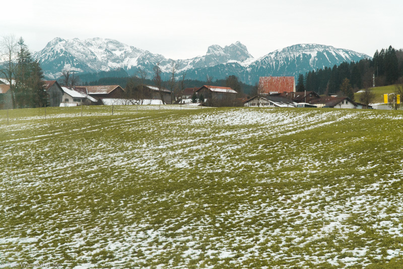 The Germany countryside with its quaint village homes and lush green hills sprinkled with fresh winter snow. 