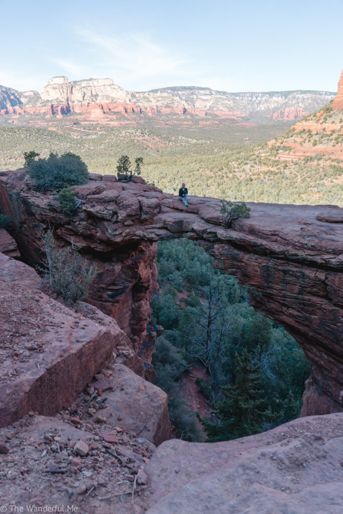 Sophie sitting on Devil's Bridge, a must-do hike when visiting Sedona on your Arizona trip. 