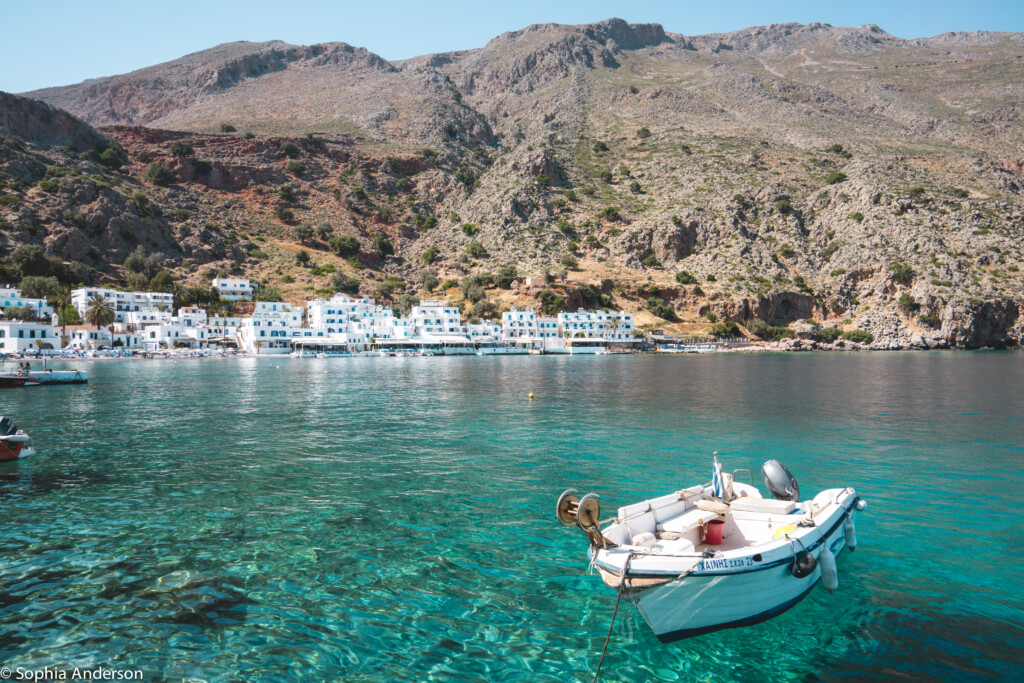 Floating boat in the turquoise-blue waters of Loutro on the Greek island of Crete. | Greece Travel Tips | The Wanderful Me