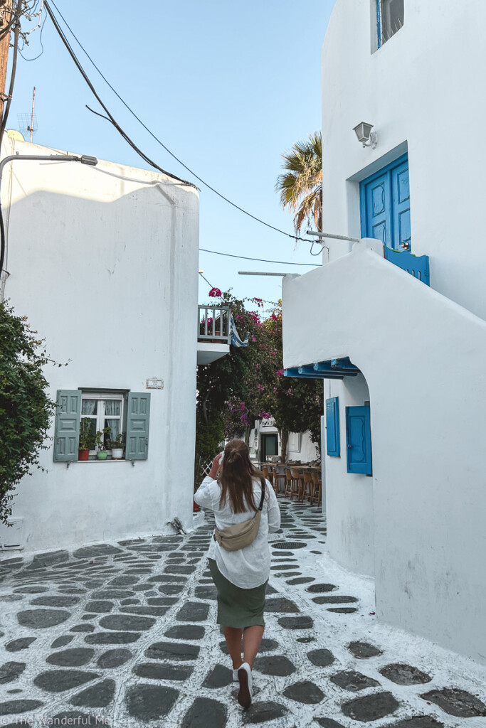 Sophie walking through the gorgeous streets of Mykonos while island hopping through Greece. 