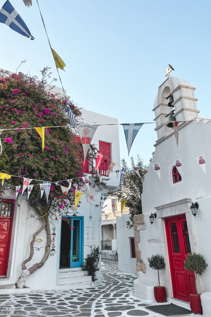 White-washed buildings with blue shutters and vibrant red doors on the island of Mykonos in Greece. 